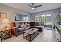 Living room with L-shaped sofa, coffee table, and sliding glass doors at 1730 Manasota Beach Rd # 115, Englewood, FL 34223