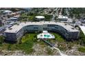 Aerial view of condo building with pool and beach access at 4450 Gulf Blvd # 104, St Pete Beach, FL 33706