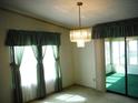 Bright dining room with a chandelier, window curtains, and access to a sunroom at 231 Tarpon Ln, Oldsmar, FL 34677
