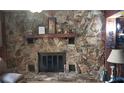 Rustic stone fireplace with a wood mantel and hearth at 8665 Mockingbird Ln, Seminole, FL 33777