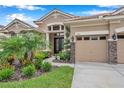 Two-story house with neutral exterior, landscaping, and three-car garage at 11519 Belle Haven Dr, New Port Richey, FL 34654
