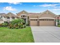 Tan two-story house with three car garage and manicured lawn at 11519 Belle Haven Dr, New Port Richey, FL 34654
