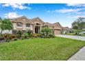 Two-story house with neutral exterior, lush landscaping, and driveway at 11519 Belle Haven Dr, New Port Richey, FL 34654