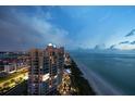 A dusk view of the multi-story building, showcasing its proximity to the beach and city lights at 1540 Gulf Blvd # 2102, Clearwater Beach, FL 33767