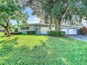 Charming single-story home with a well-manicured lawn and a two-car garage at 161 Overbrook W St, Largo, FL 33770