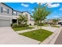 Two-story townhome with gray siding, two-car garage, and landscaped front yard at 7203 Sweet Alyssum Ct, Tampa, FL 33619