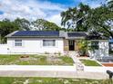 White house with solar panels, a walkway, and landscaping at 104 11Th S Ave, Safety Harbor, FL 34695