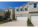 Tan two-story townhouse with white garage door at 2313 Sunset Wind Loop, Oldsmar, FL 34677