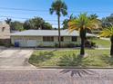 Ranch-style home with attached two-car garage and mature landscaping at 7979 Garden N Dr, St Petersburg, FL 33710