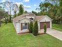 Single-story house with a brown garage door and manicured lawn at 2193 Peake St, North Port, FL 34286