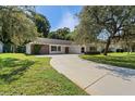 This house features long driveway, green lawn, and unique brick accent at 12912 Willoughby Ln, Hudson, FL 34667