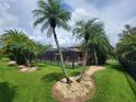 Screened pool area with patio furniture and lush tropical landscaping at 7607 55Th E St, Ellenton, FL 34222