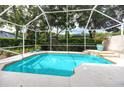 Screened-in pool with waterfall feature at 3570 Golfside Dr, Palm Harbor, FL 34685