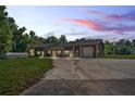 Home with stone accents and large windows at dusk at 13600 Ponce De Leon Blvd, Brooksville, FL 34601