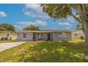 Gray house with black door and green lawn at 6840 Runnel Dr, New Port Richey, FL 34653