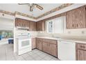 Bright kitchen with white appliances and wood cabinets at 4445 Pelorus Dr, New Port Richey, FL 34652