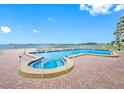 A serene condo pool and spa area with lovely bay views, perfect for relaxation and enjoyment at 300 Woodette Dr # 202B, Dunedin, FL 34698