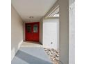 Inviting home entrance featuring a striking red double door and neutral exterior at 2502 Indigo Dr, Dunedin, FL 34698