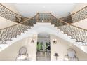 Elegant double staircase with ornate railings in a large foyer at 2901 Leprechaun Ln, Palm Harbor, FL 34683