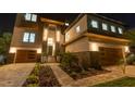Beautiful two-story home featuring stone accents, sleek wood garage doors, and manicured landscaping at 2121 Bayou Grande Ne Blvd, St Petersburg, FL 33703