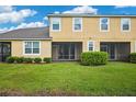 Landscaped backyard with a screened patio and grassy area at 2503 Arch Ave # 139W, Oldsmar, FL 34677