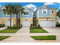 Two story townhome with a yellow and blue exterior, two car garage and landscaping at 2503 Arch Ave # 139W, Oldsmar, FL 34677