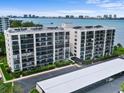 Exterior view of condominium building showing many units with balconies and waterfront views at 100 Oakmont Ln # 301, Belleair, FL 33756