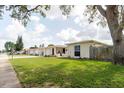 A traditional single-story home showcasing a tidy lawn and easy access to the neighborhood sidewalk at 1172 Chelsea Ln, Holiday, FL 34691