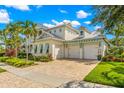 Two-story home with light-colored siding, a metal roof, and a paver driveway at 709 Manns Harbor Dr, Apollo Beach, FL 33572