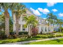Two-story home with light-colored siding, a metal roof, and lush landscaping at 709 Manns Harbor Dr, Apollo Beach, FL 33572