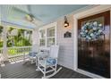 Inviting front porch with rocking chairs and a ceiling fan, perfect for relaxing at 106 19Th Ave, St Pete Beach, FL 33706