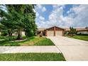 House exterior showcasing landscaping and a two-car garage at 2014 Montego Ct, Oldsmar, FL 34677