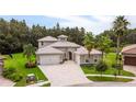 Two-story house with a large driveway and landscaping at 32801 Estate Garden Dr, Wesley Chapel, FL 33545