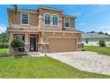 Two-story house with tan exterior, stone accents, and paver driveway at 116 Caladium Ct, Bradenton, FL 34212