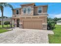 Two-story house with tan exterior, stone accents, and paver driveway at 116 Caladium Ct, Bradenton, FL 34212