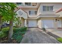 Front view of townhouse with two-car garage and landscaping at 4654 Mirabella Ct, St Pete Beach, FL 33706
