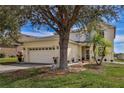 Two-story house with a large front yard, attached garage, and landscaping at 8556 Southern Charm Cir, Brooksville, FL 34613