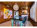 Bright dining room with unique teal table, wood walls, and large artwork at 113 93Rd Ave, Treasure Island, FL 33706