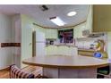 Galley style kitchen with light cabinets and a curved kitchen island at 192 Blue Marlin Dr, Oldsmar, FL 34677