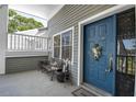 Inviting condo entryway with blue door, bench, and potted plants at 2599 Dolly Bay Dr # 308, Palm Harbor, FL 34684