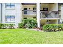 Well-maintained condominium building with lush green lawn and manicured shrubs at 2400 Winding Creek Blvd # 25-101, Clearwater, FL 33761