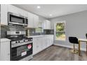 Modern white kitchen with stainless steel appliances and gray backsplash at 1216 15Th S Ave, St Petersburg, FL 33705