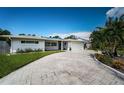 Well-maintained home featuring a paved driveway, lush lawn, and a two-car garage at 4751 Baywood Point S Dr, Gulfport, FL 33711