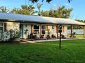 Inviting front porch with rocking chairs, a swing, decorative shutters, and well-maintained landscaping at 7809 Alafia Dr, Riverview, FL 33578
