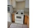 Basic kitchen with white appliances and light wood cabinets at 6100 12Th S St # 211, St Petersburg, FL 33705
