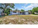 One-story home with gray siding, attached garage, and a spacious lawn at 9406 Rainbow Ln, Port Richey, FL 34668