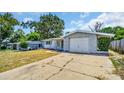 Front view of a house with a gray stone facade and a driveway at 9406 Rainbow Ln, Port Richey, FL 34668