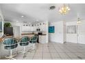 Kitchen features a breakfast bar, white cabinets, and tiled floors at 11220 9Th E St, Treasure Island, FL 33706