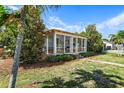 Bungalow showcasing a sunroom and lush landscaping at 5214 Gulfport S Blvd, Gulfport, FL 33707