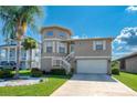 Tan two-story house with attached garage and landscaping at 6240 Bayside Dr, New Port Richey, FL 34652